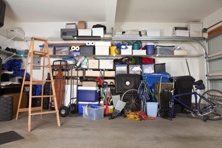 Suburban garage mess.  Boxes, tools and toys in disarray.
